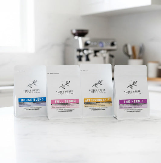 Four coffee packages on a kitchen counter with a blurred background